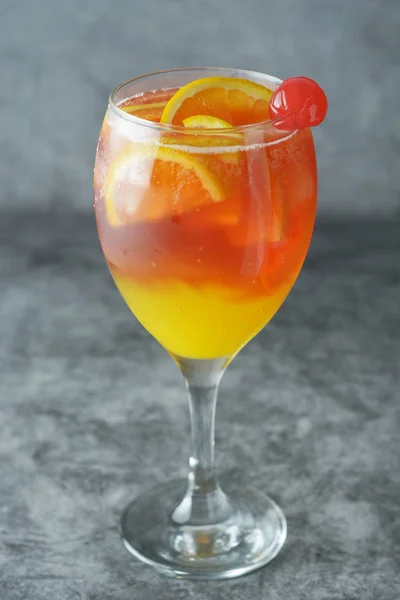 夏のカクテルミント、シロップ、フルーツスライス、チェリーと氷のオレンジジュース。暗い背景. — ストック写真