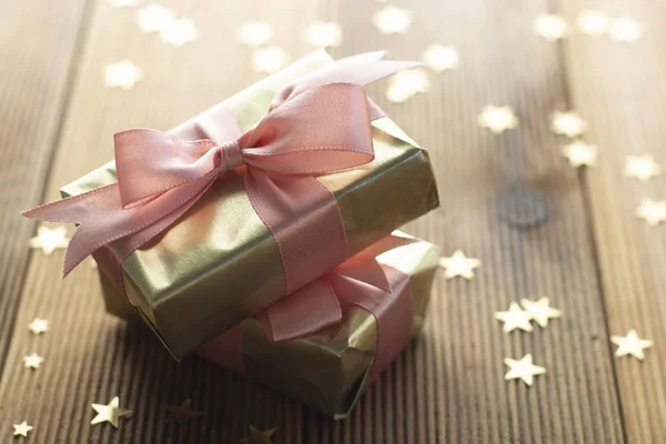 Beaux cadeaux dorés Noël, fête, fond d'anniversaire. Célébrez shinny boîtes surprises copier l'espace fond en bois — Photo