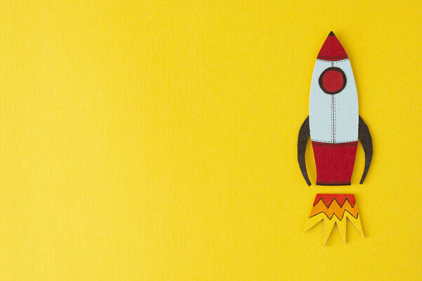 Start up business concept. Boost or increase incomes, salary. Drawn rocket on colorful yellow background. Copy space.