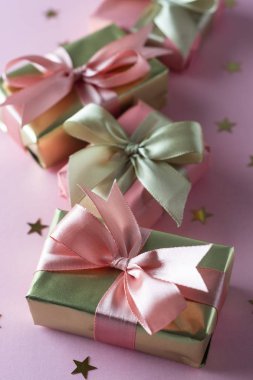 Altın ve pembe hediye kutusu pembe arka plan üzerinde izole. Doğum günü, güzellik partisi konsepti.