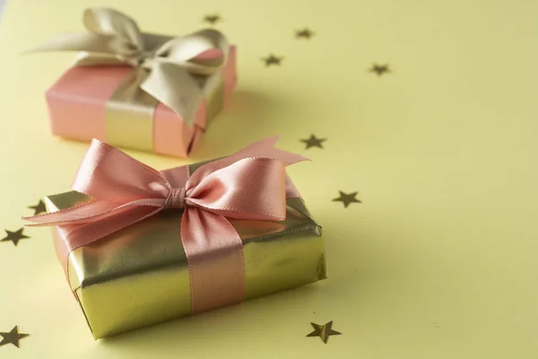 金色和粉红色的礼品盒隔离在黄色背景上。生日，圣诞派对模拟. — 图库照片