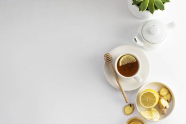 Black tea with lemon and honey on a white background. Hot tea cup isolated, top view flat lay. Flat lay. Autumn, fall or winter drink. Copy space. clipart