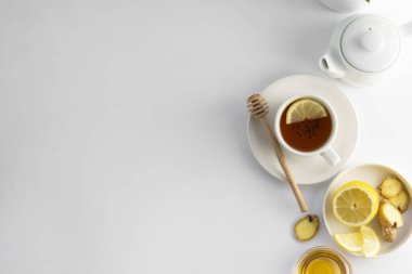 Beyaz bir arka plan üzerinde limon ve bal ile siyah çay. Sıcak çay bardağı izole, üst görünüm düz yatıyordu. Düz yatıyordu. Sonbahar, sonbahar veya kış içeceği. Kopyalama alanı.