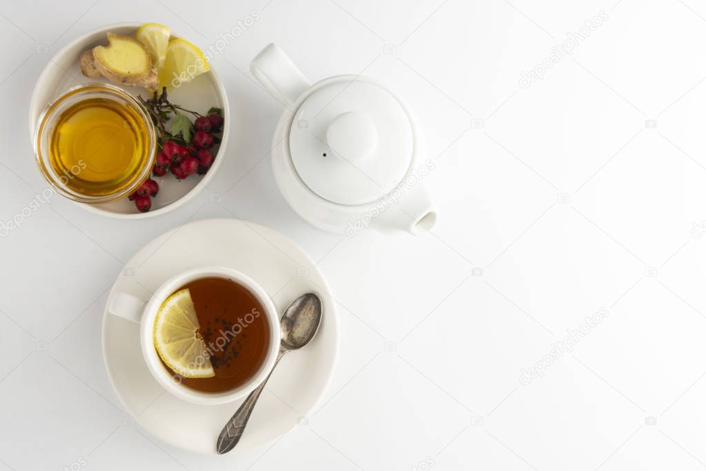Black tea with lemon and honey on a white background. Hot tea cup isolated, top view flat lay. Flat lay. Autumn, fall or winter drink. Copy space.