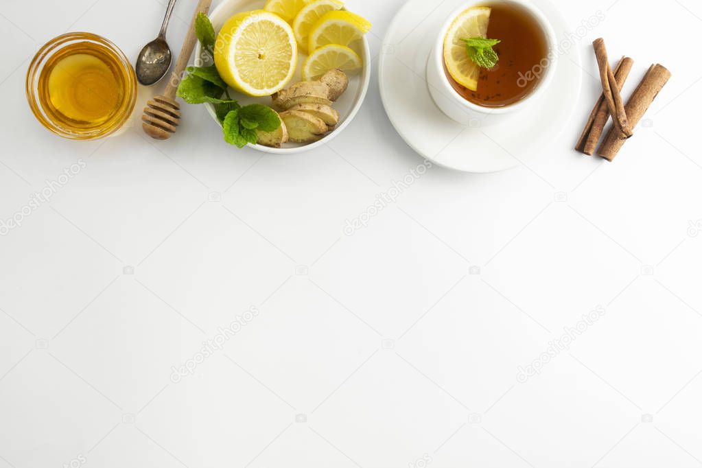 Fresh tea with lemon and honey on a white background. Hot tea cup isolated, top view flat lay. Flat lay. Autumn, fall or winter drink. Copy space.