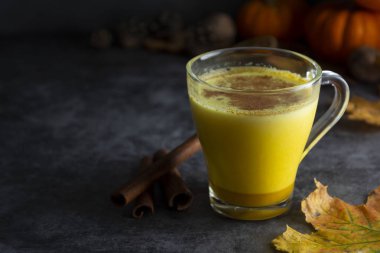 Kabak baharatlı latte macchiato koyu ahşap arka plan sonbahar içecek içecek altın süt kopya alanı ile