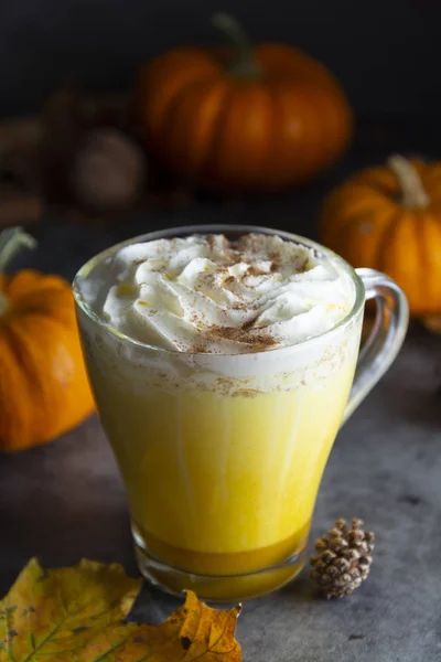 Spiced golden milk pumpkin autumn latte drink milkshake with cream foam dark black background — Stock Photo, Image