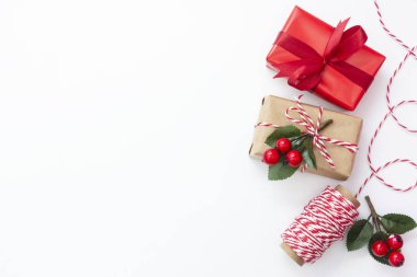 Noel arkaplanı. Beyaz arka planda el sanatları kağıdına sarılı hediye kutuları. Hediye paketlerini paketliyorum. Üst Manzara. Boşluğu kopyala.