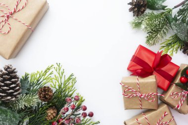 Hediye kutularıyla Noel süslemesi, şekillendirilmiş köknar dalı, çam kozalakları, beyaz arka planda çelenk. Kopyalama alanı olan üst görünüm.