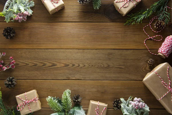 Marco de Navidad, simulacro, fondo de vacaciones de invierno. Caja de regalo de Navidad con conos de pino, brances de abeto, sobre mesa de madera marrón. Piso de Navidad laico, espacio de copia . — Foto de Stock