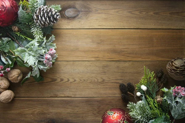 Χριστουγεννιάτικο φόντο, frme, μακέτα συνόρων επάνω. Κώνους πεύκου, ελεφαντόδοντο, κόκκινα μπιχλιμπίδια σε καφέ ξύλινο τραπέζι με χώρο αντιγραφής. Χριστούγεννα επίπεδη lay. — Φωτογραφία Αρχείου