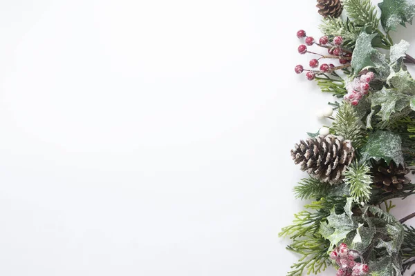 Karácsonyi dekoráció, stílus fenyő ágak, fenyő toboz, koszorú fehér alapon. Felülnézet másolási hellyel. — Stock Fotó