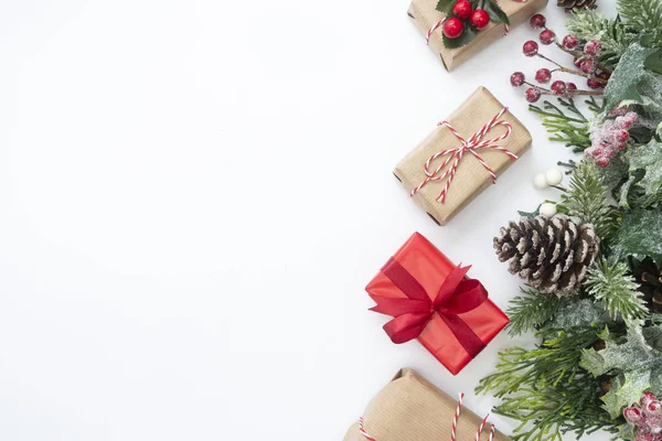 Juldekoration med presentaskar, stylad gran gren, kottar, krans på vit bakgrund. Ovanifrån med kopieringsutrymme. — Stockfoto