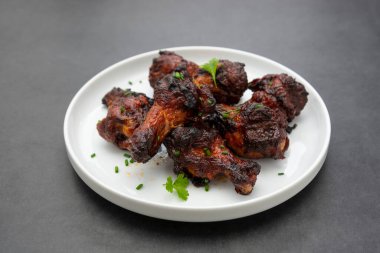 Barbekü tavuk bacağı, kanatlar, tabakta bagetler..