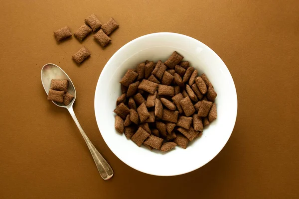 速食碳水化合物垃圾食品碗褐色背景的巧克力麦片圈 顶部视图 — 图库照片