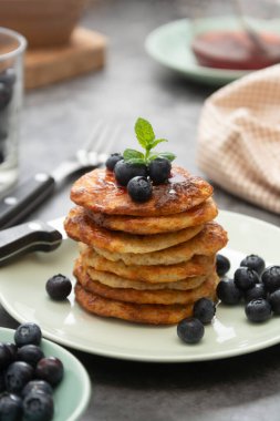 Yaban mersinli krep yığını, koyu arkaplanda sağlıklı kahvaltı.