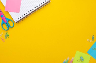Eğitim geliştirme konsepti. Okula dönelim. Okul gereçleri, not defteri, roket ve yapışkan notlarla dolu sarı arka plan. Model yap. Düz yatıyordu.