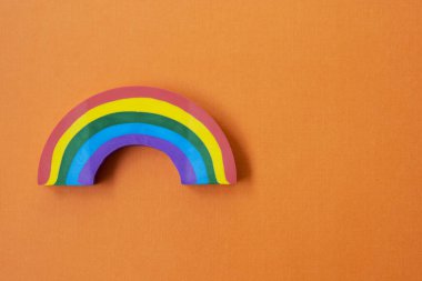 Turuncu arka planda gökkuşağı nesnesi. LGBT konsepti. Metin için kopyalama alanı olan eğitim arkaplanı.