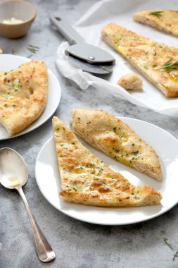 Sarımsaklı Focacia ekmeği dilimleri. Taze pişmiş sarımsaklı ekmek, zeytinyağı ve bitkiler..