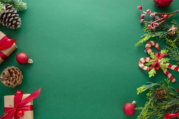 圣诞绿色背景 配有冬季装饰 礼品盒 冷杉枝条 松果和红色灌木丛 复制空间 — 图库照片
