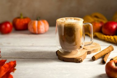 Elma ve tarçınlı, portakal kabaklı, ahşap kırsal arka planlı rahat sonbahar kahvesi..