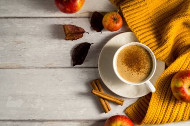 Elma ve tarçınlı, portakal kabaklı, ahşap kırsal arka planlı rahat sonbahar kahvesi..