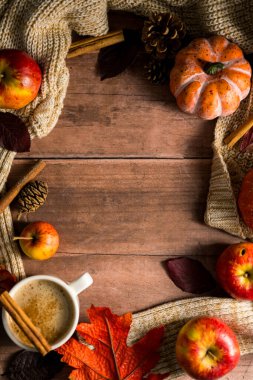 Sıcak içecek çerçevesi, elmalı ve tarçınlı sıcak sonbahar kahvesi, portakal kabakları, ahşap kırsal arka plan..