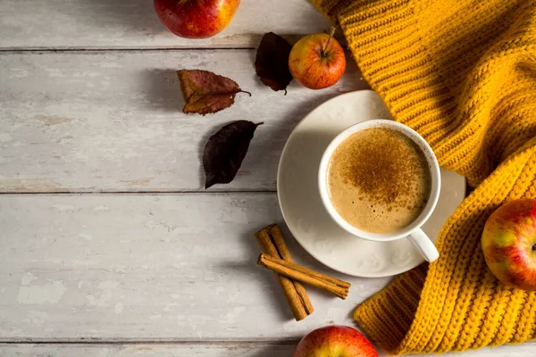 Elma ve tarçınlı, portakal kabaklı, ahşap kırsal arka planlı rahat sonbahar kahvesi..