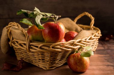 Sepette taze toplanmış kırmızı elmalar, kırsal ahşap arka plan.