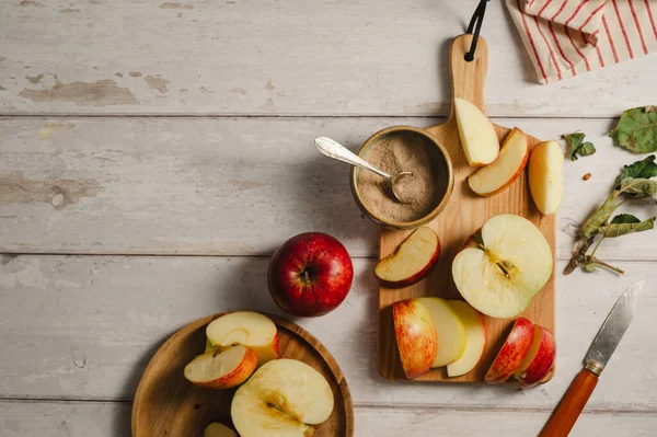 Kırmızı elmalar, ahşap bir kesme tahtasının üzerinde dilimlenmiş, yaşam tarzı, üst manzara. Sonbahar soyut gıda arkaplanı