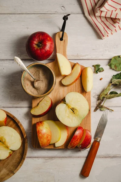 Kırmızı elmalar, ahşap bir kesme tahtasının üzerinde dilimlenmiş, yaşam tarzı, üst manzara. Sonbahar soyut gıda arkaplanı