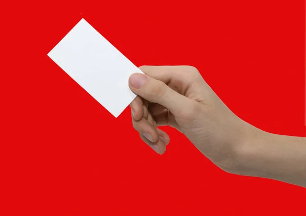 赤い背景に白いカードを持つ男性の手 — ストック写真