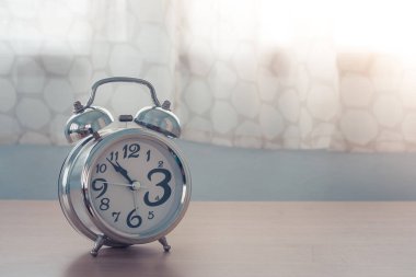 Eski gümüş çalar saat içinde belgili tanımlık geçmiş beyaz perde yatak odası ahşap tablo kapatın. (Seçici odak)