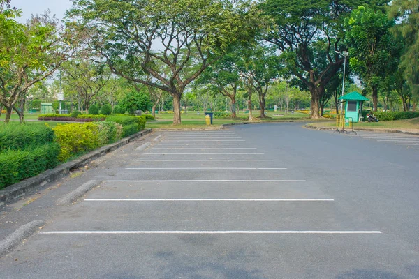 空スペースの駐車場公共の公園でバック グラウンドで緑の木々 選択と集中 — ストック写真