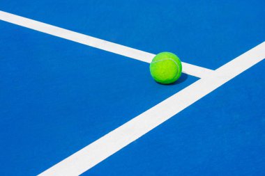 Yeşil topu yere neredeyse beyaz çizgiler açık mavi tenis sabit mahkeme genel Park düşüyor. (Seçici odak)