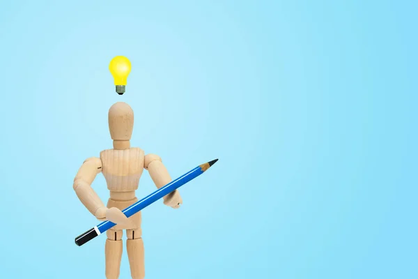 商业创意和理念概念 木图人体模型手拿着蓝色铅笔 头上有黄色灯泡 — 图库照片