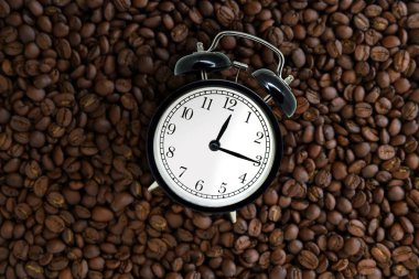 Kahve break kavramı: üst görünüm Retro siyah çalar saat kahve çekirdekleri üzerinde yalan.