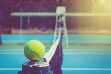 NET kutup ve kamu parkta açık mavi tenis sert mahkeme siyah net üzerinde yeşil top yer. (Seçici odak)