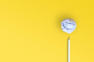 İş fikir kavramı: beyaz kalem ve sarı zemin koymak kırılmış kağıt topu.