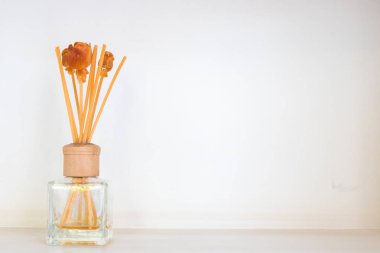 Aroma mür çubukları ve oturma odasında rafa cam şişe yerde uçucu yağ neredeyse beyaz duvar.