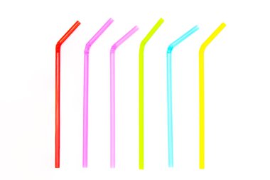 Beyaz arka planda izole renkli plastik içme pipetleri yığını.