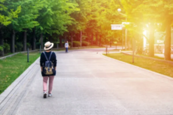 Abstract blurred image of Alone woman walking on pathway or footpath in Nakajima park (Koen) Hokkaido, Japan.