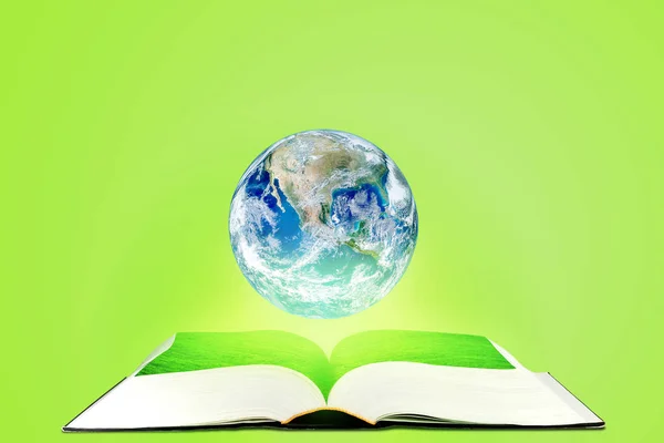 生态与教育理念 行星地球地球漂浮在以绿色为背景的打开书上 这张图片的元素由美国宇航局提供 — 图库照片