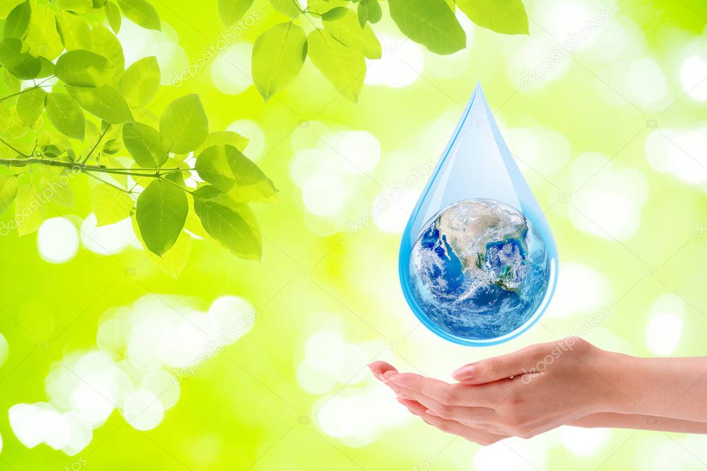 Ecology Concept : Woman hand holding planet earth globe in water drop with green natural in background. (Elements of this image furnished by NASA.)