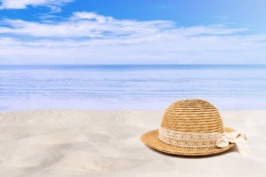 Yaz Tatili ve Tatil Gezisi Konsepti : Arka planda deniz ve mavi gökyüzünün güzel deniz manzarasına sahip kum plajında örme şapka.