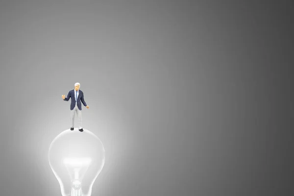 经营理念理念 商人站在灯泡上 — 图库照片