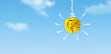 İş Fikri: Arkaplanda mavi gökyüzü olan buruşmuş top kağıdından yapılmış sarı ampul.