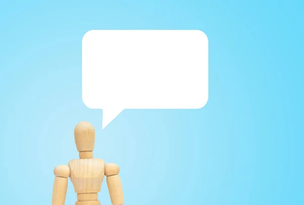 ビジネスコミュニケーションコンセプト 青い背景を持つ木製の人形マネキンの頭の上に空の白いスピーチバブルチャット — ストック写真
