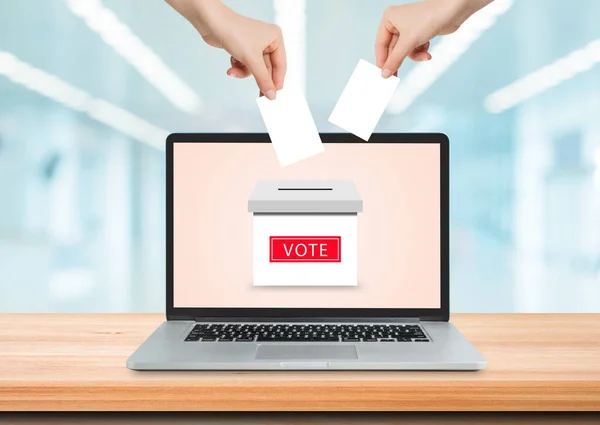 オンライン投票の概念 ノートパソコンの画面上の投票箱に投票用紙カードを保持し — ストック写真