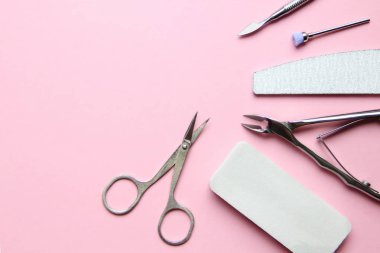 Pembe arka planda manikür ve pedikür için temel araçlar